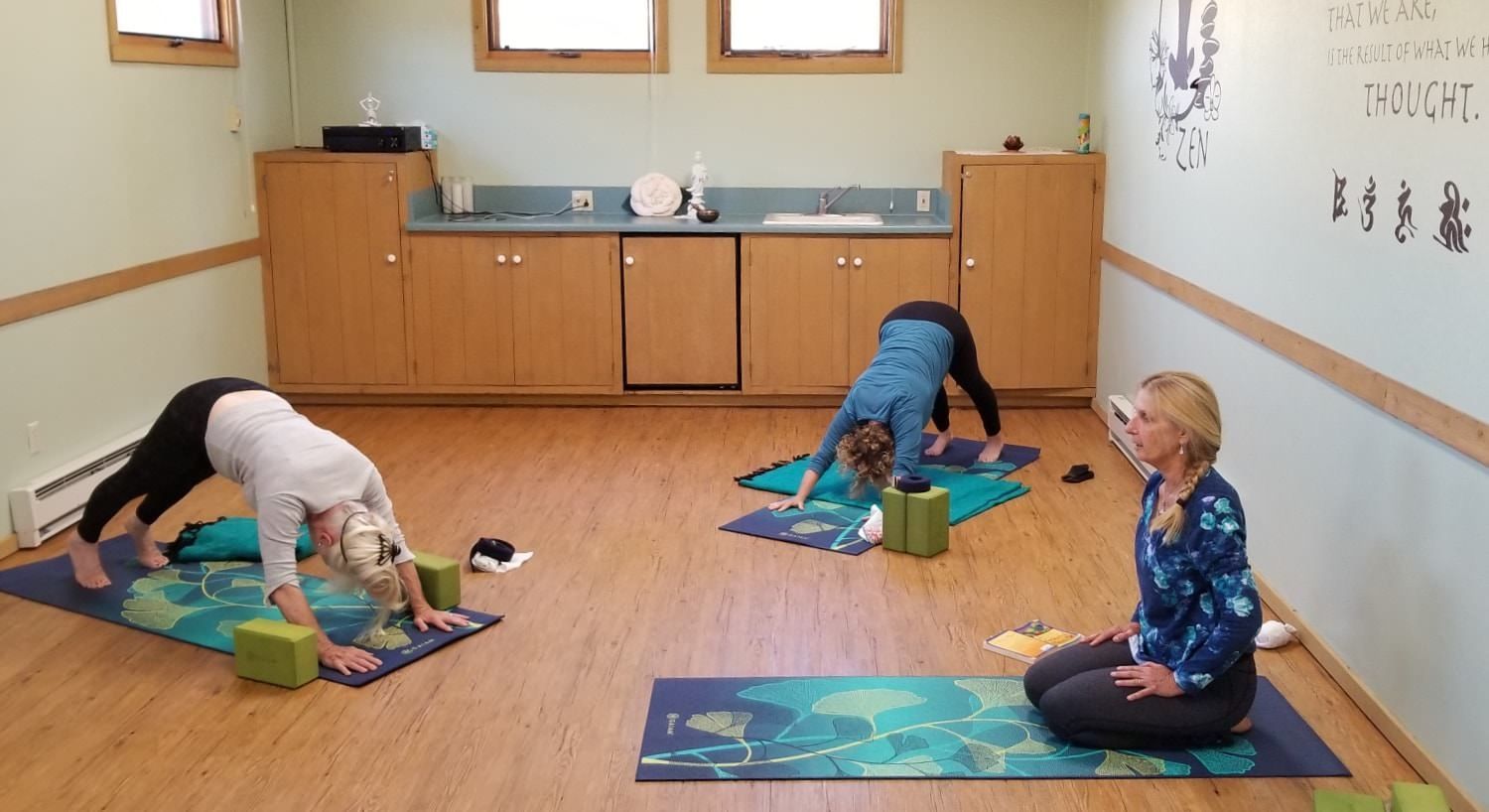 A group of people are doing yoga in a room.