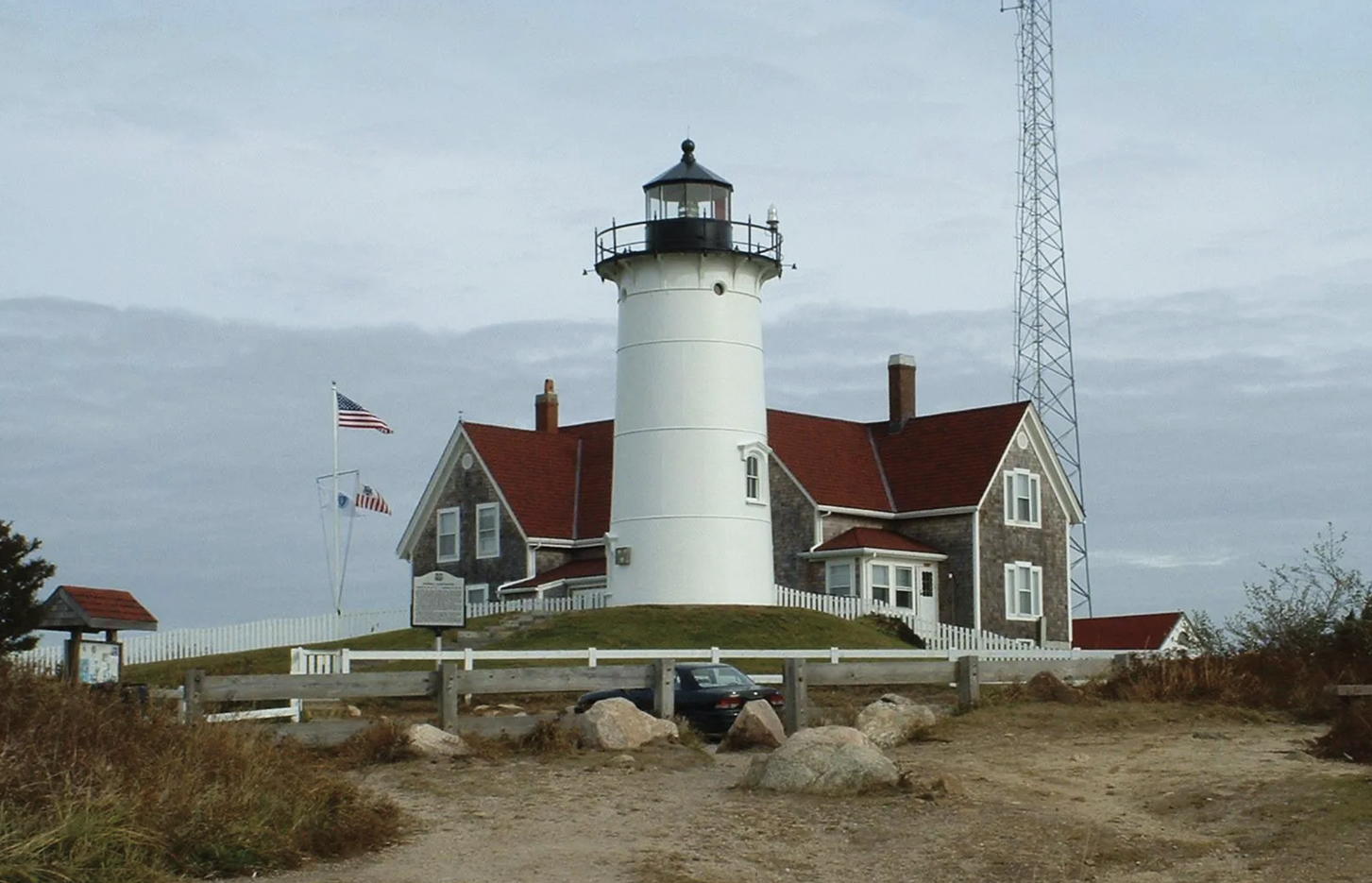 A large white lighthouse with a red roof