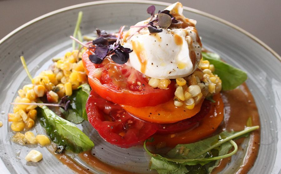 A plate of food with tomatoes and corn on it