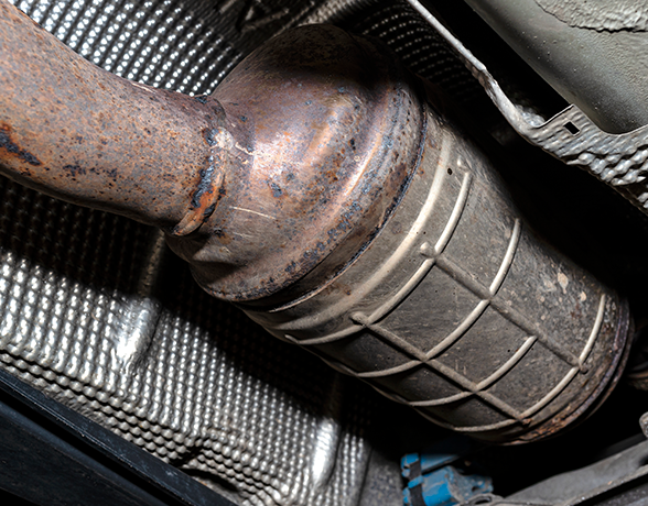 A close up of a rusty diesel particulate filter in a car