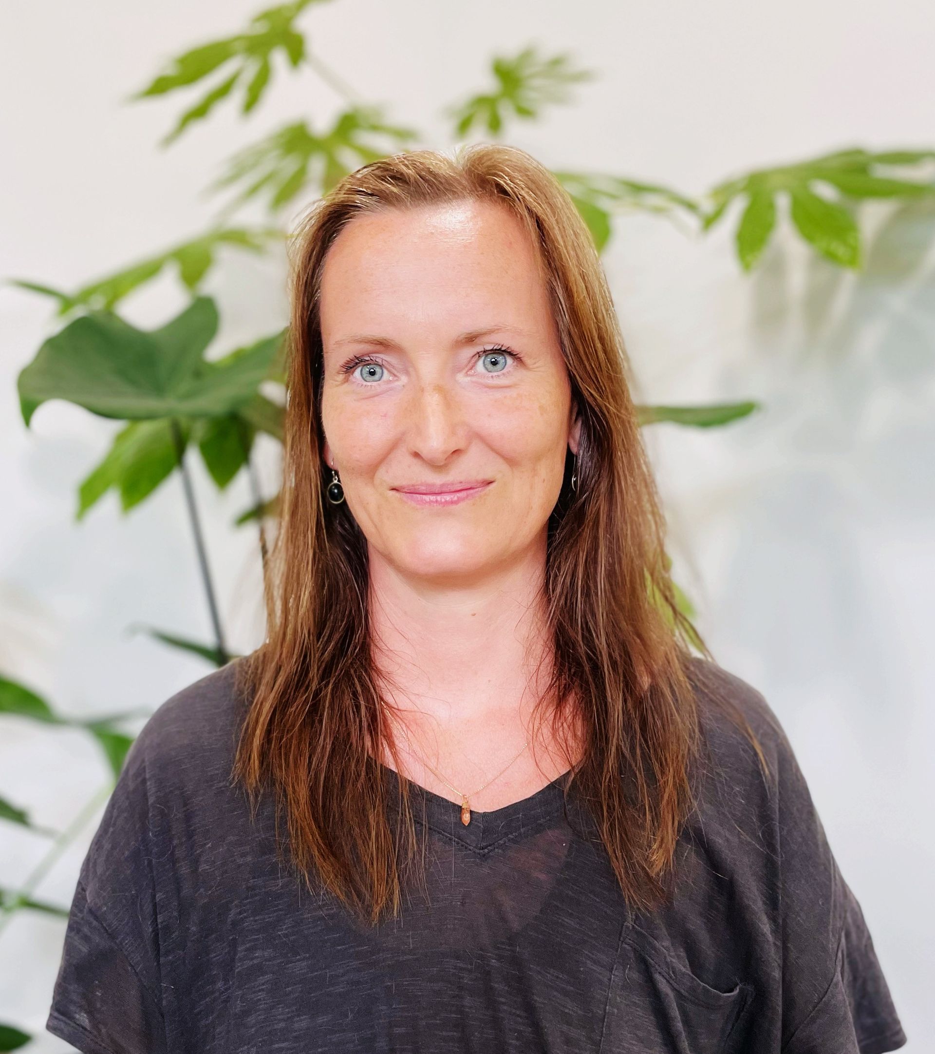 Underviser Catrine med langt brunt hår og blå øjne smiler til kameraet.