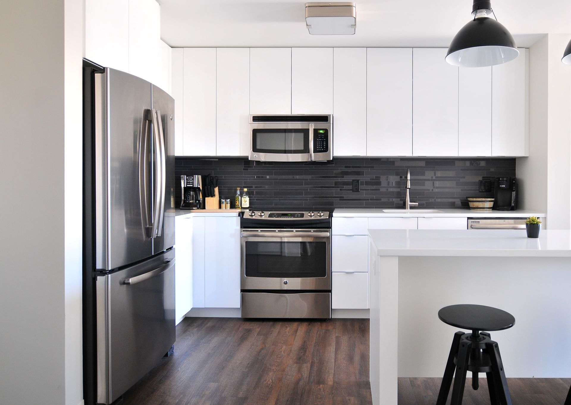 A kitchen with stainless steel appliances and white cabinets