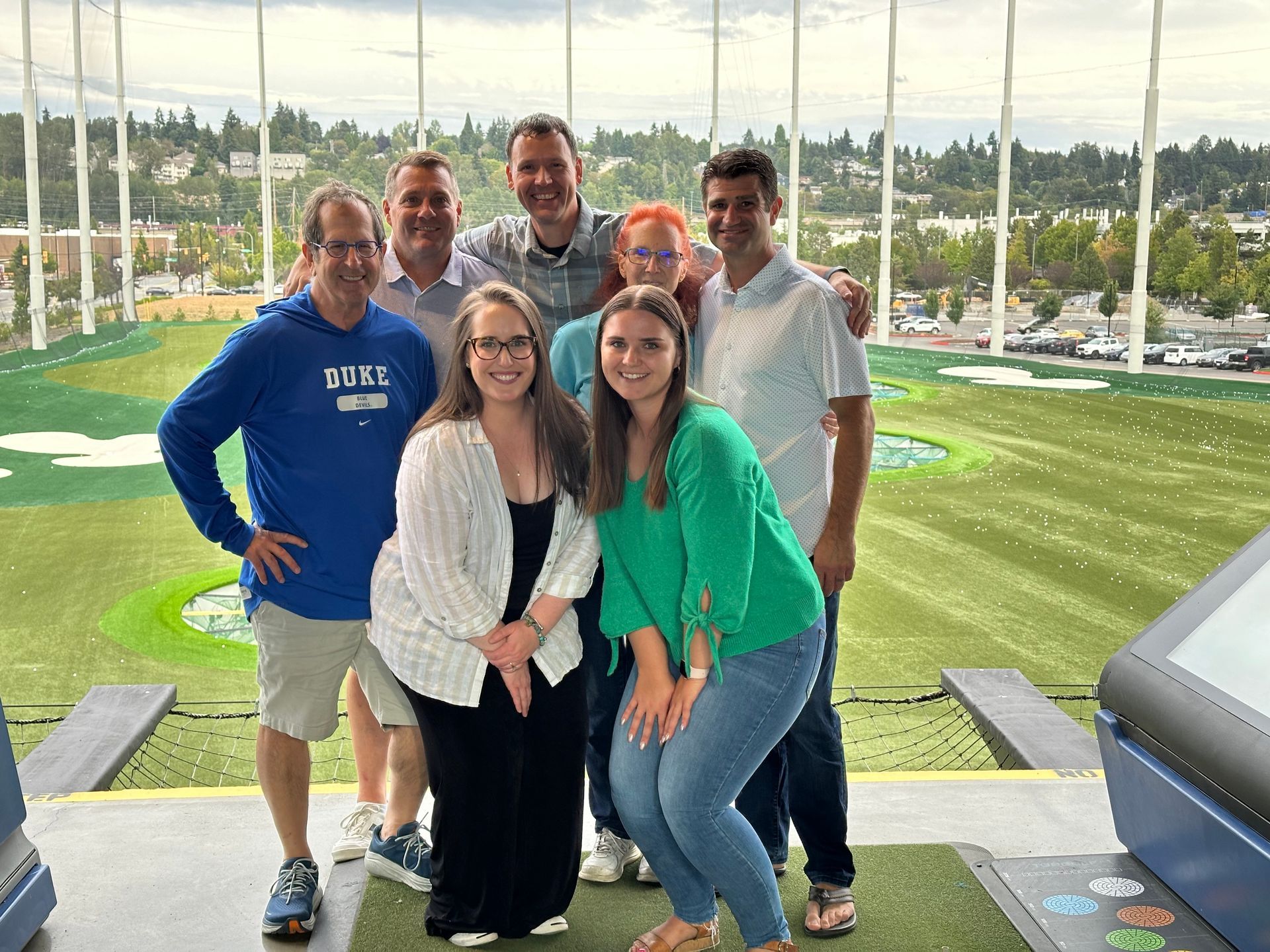 A group of people are posing for a picture on a golf course.