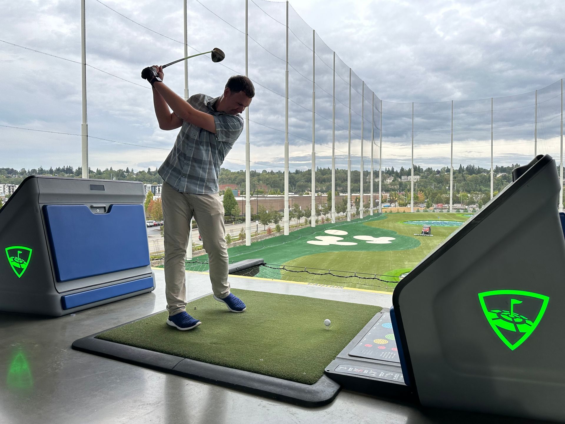 A man is swinging a golf club on a golf course.