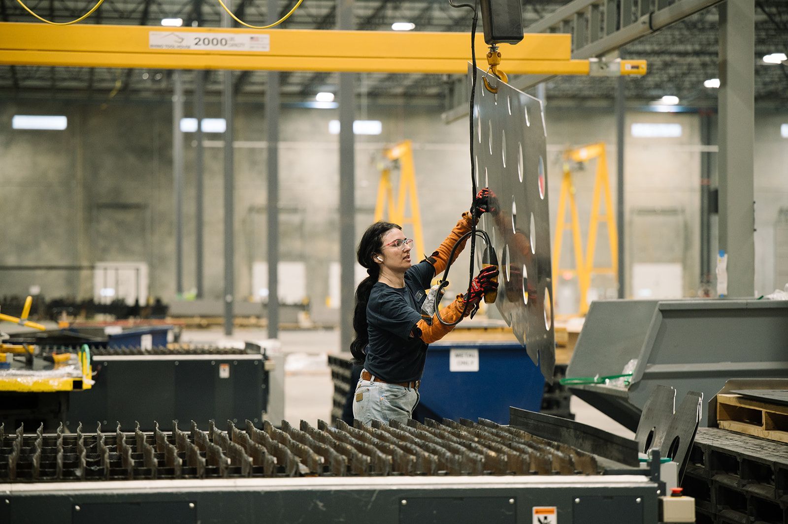 Close-up of a high-power CNC fiber laser cutter processing steel plate with intricate detail.
