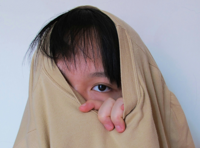 A person covering their face with a piece of cloth