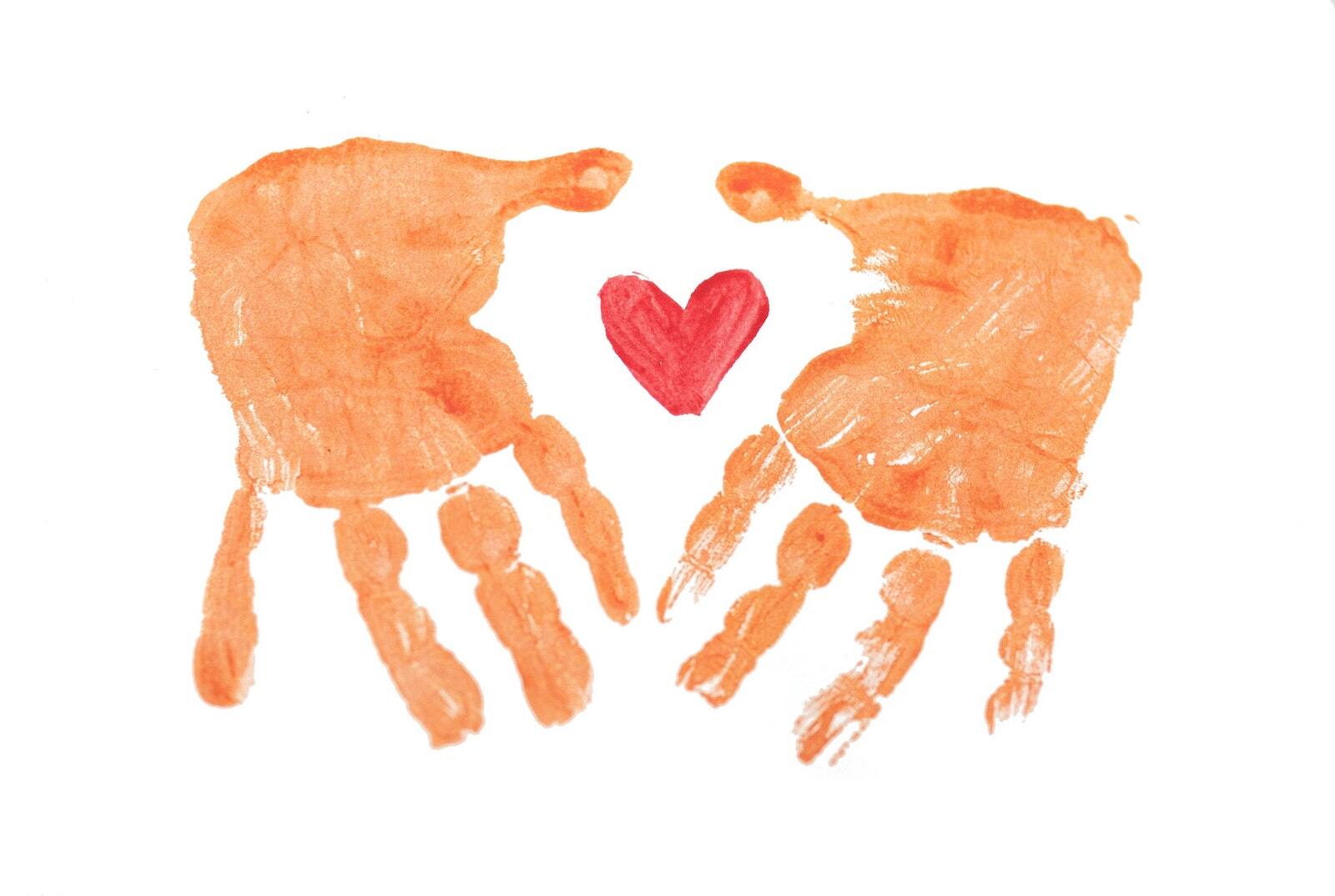 Two hand prints with a red heart in the middle