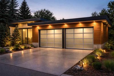 Modern garage with frosted glass doors, wooden siding, and exterior accent lighting at dusk.