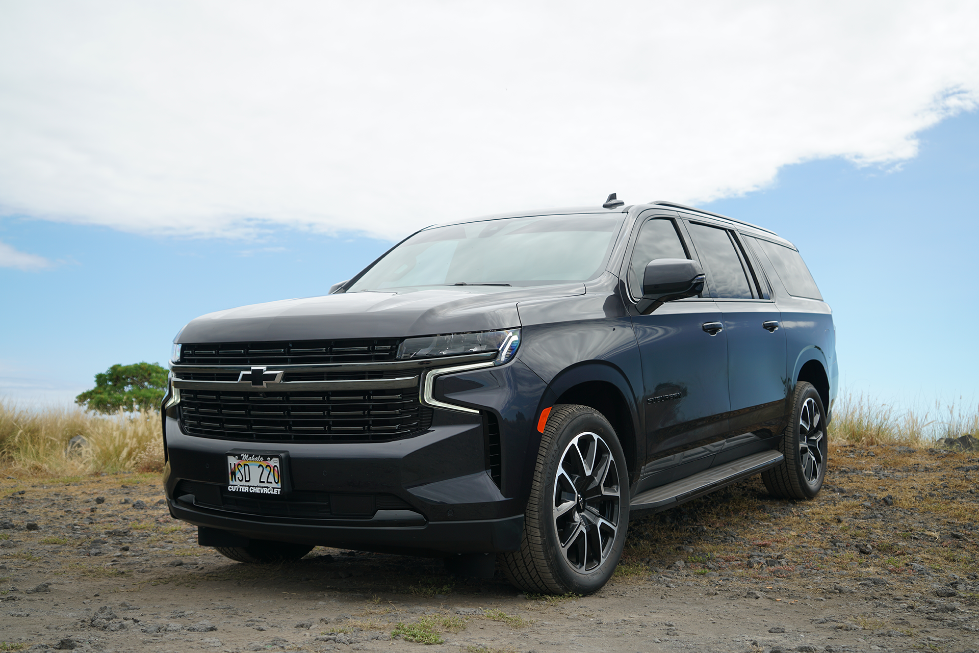 A black suv is parked on a dirt road.