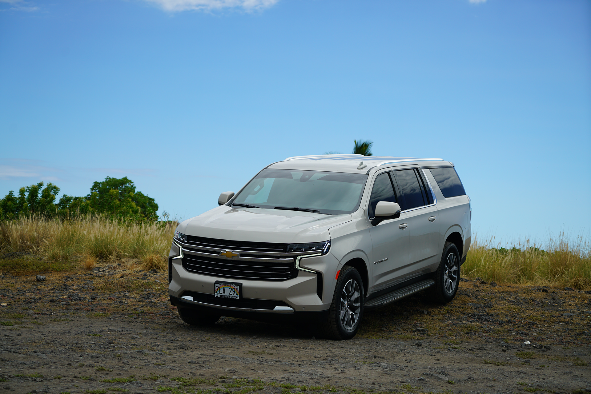 A white suv is parked in a dirt field.