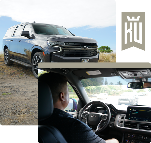 A man is driving a suv with a ku logo in the background