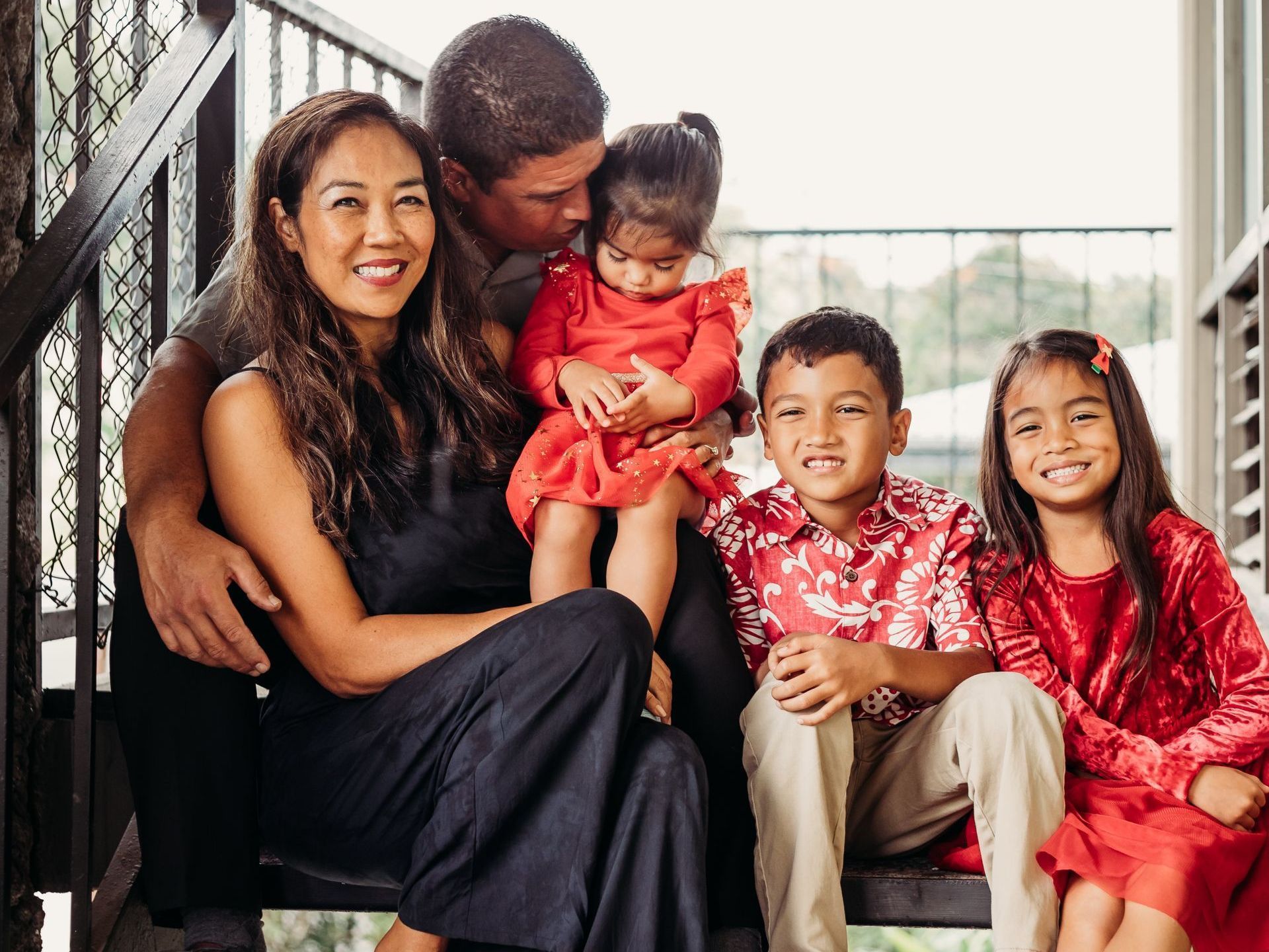 A family is posing for a picture on a balcony.