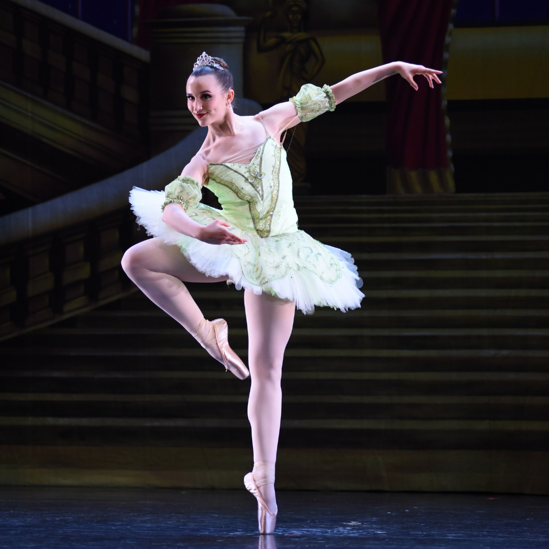 a ballerina is dancing on a stage with stairs in the background