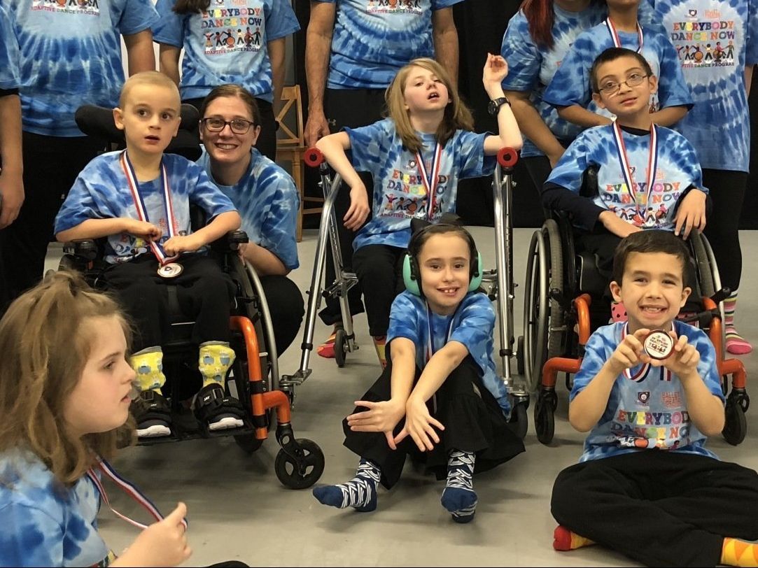 a group of children in wheelchairs are posing for a picture .
