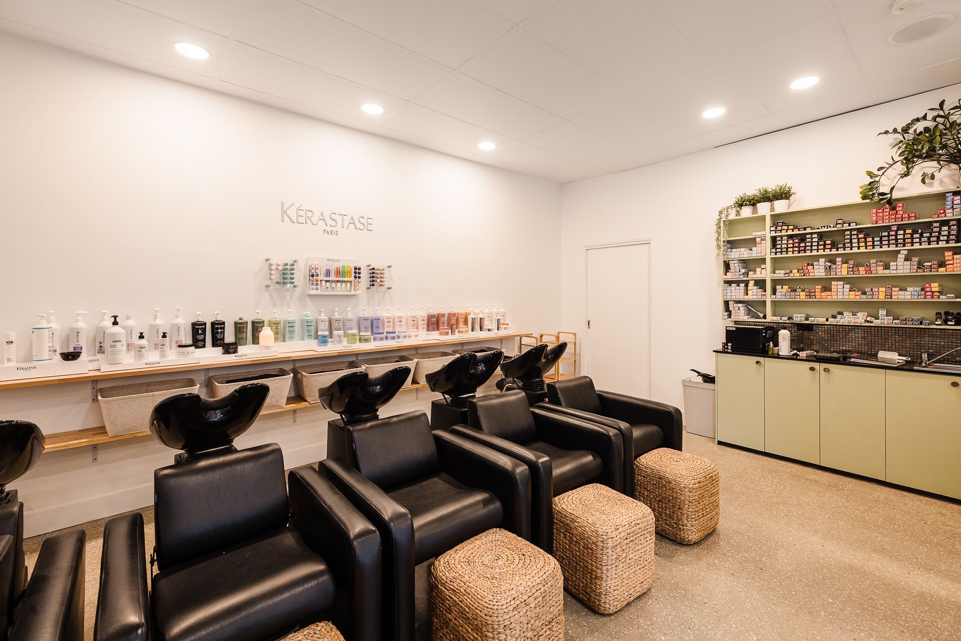 A room with a lot of chairs and sinks in it.