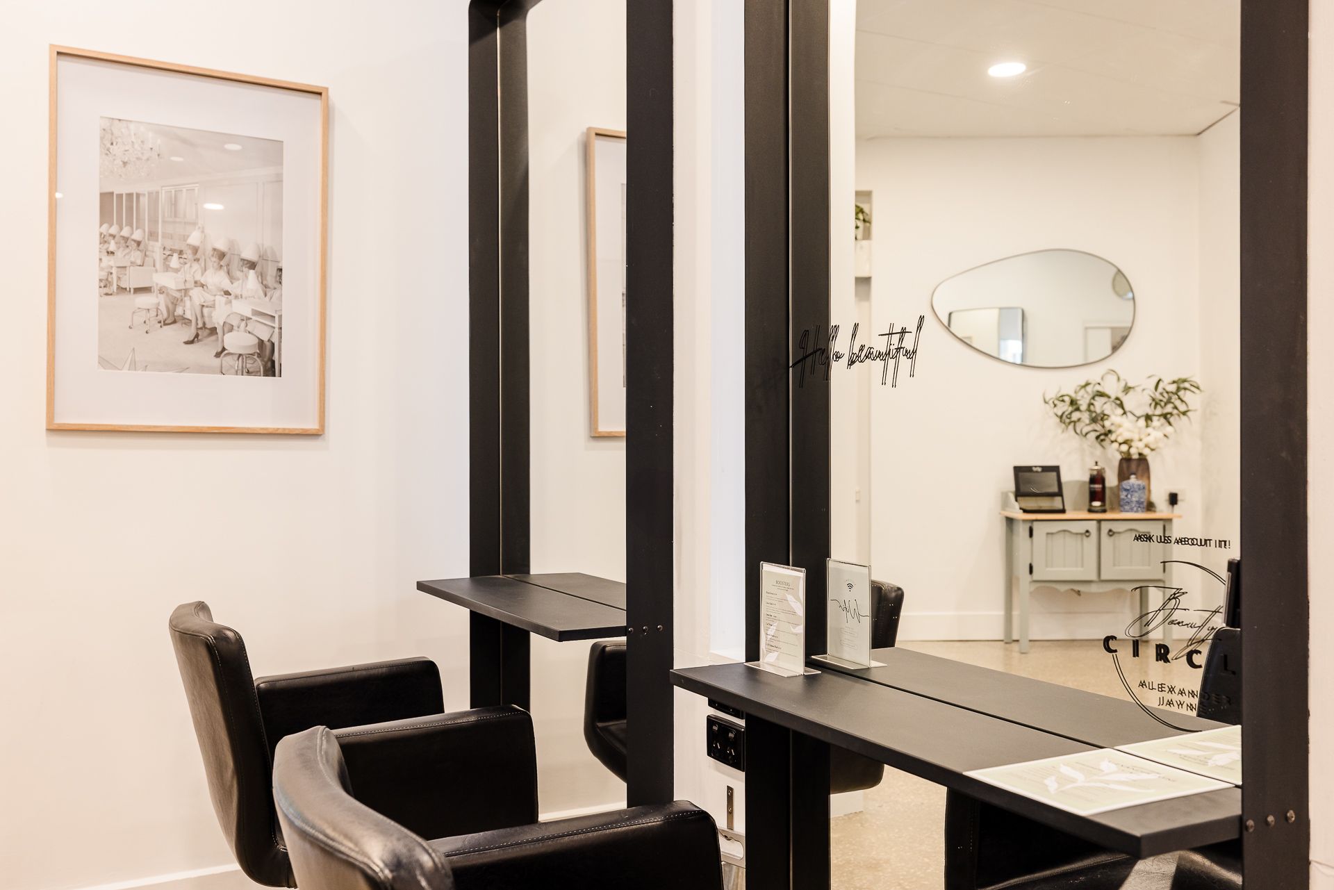 A hair salon with two chairs and two tables.