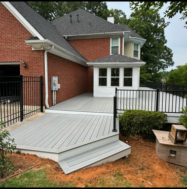 A brick house with a gray deck in front of it