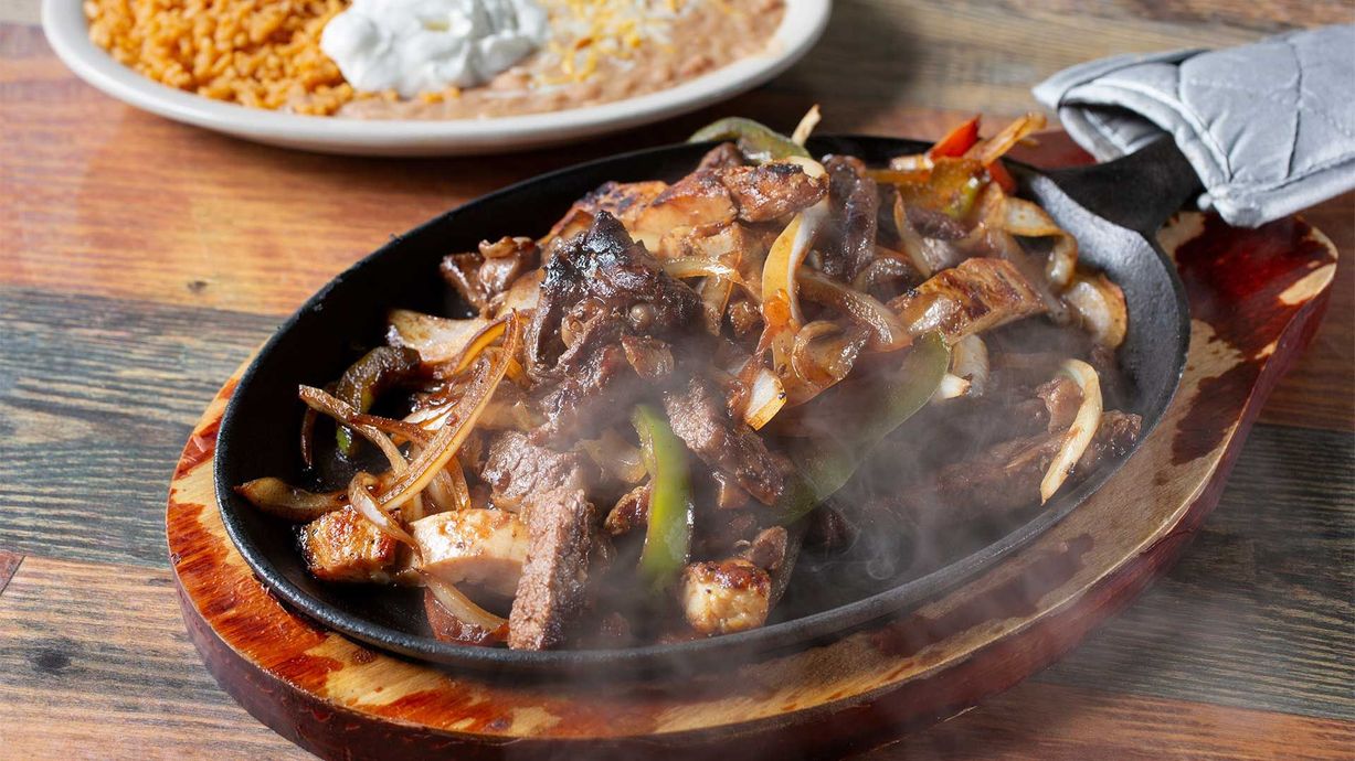 A close up of a plate of food on a wooden table.