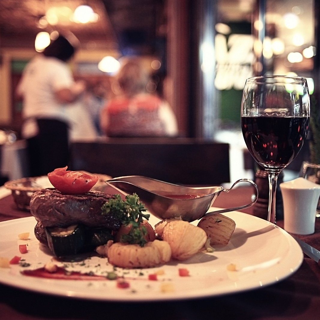 A plate of food and a glass of wine on a table