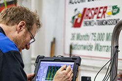 Mechanic using a diagnostic tablet in a shop; a 