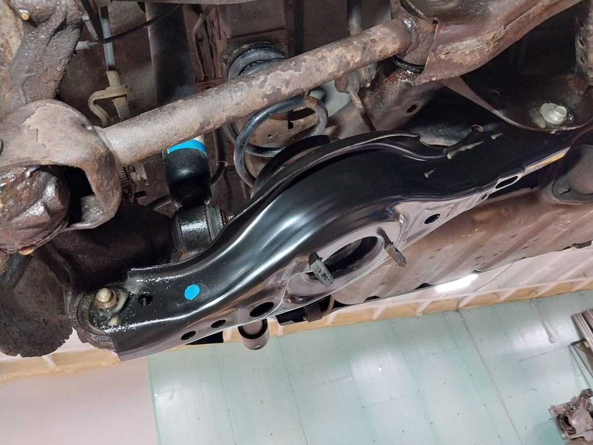 Black car suspension component with shock absorber and control arm. | Accomplished Automotive