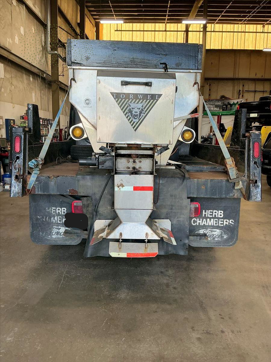 Rear view of a Herb Chambers truck with a salt spreader attachment. | Accomplished Automotive