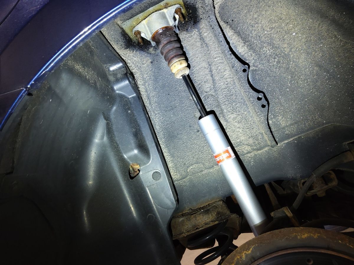 Rear car suspension with a shock absorber visible. Silver and black. | Accomplished Automotive