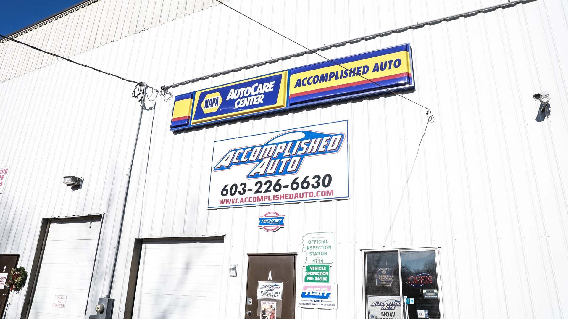 Accomplished Auto sign on a white building, with a smaller Napa AutoCare Center sign above.