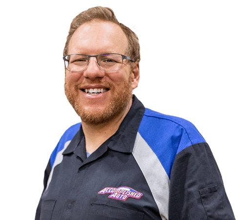 Smiling man wearing glasses and a blue and black uniform shirt.