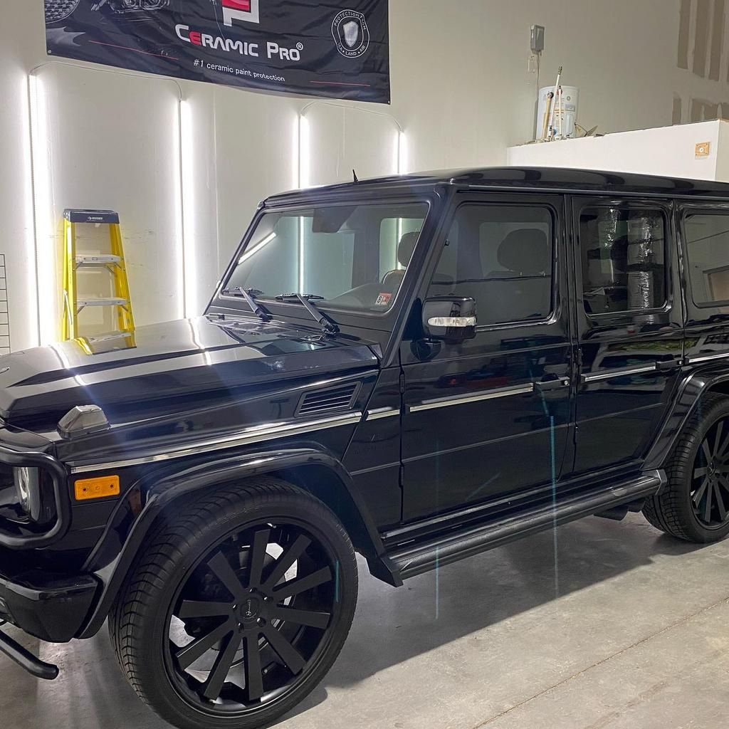 a black jeep is parked in a garage next to a ladder .