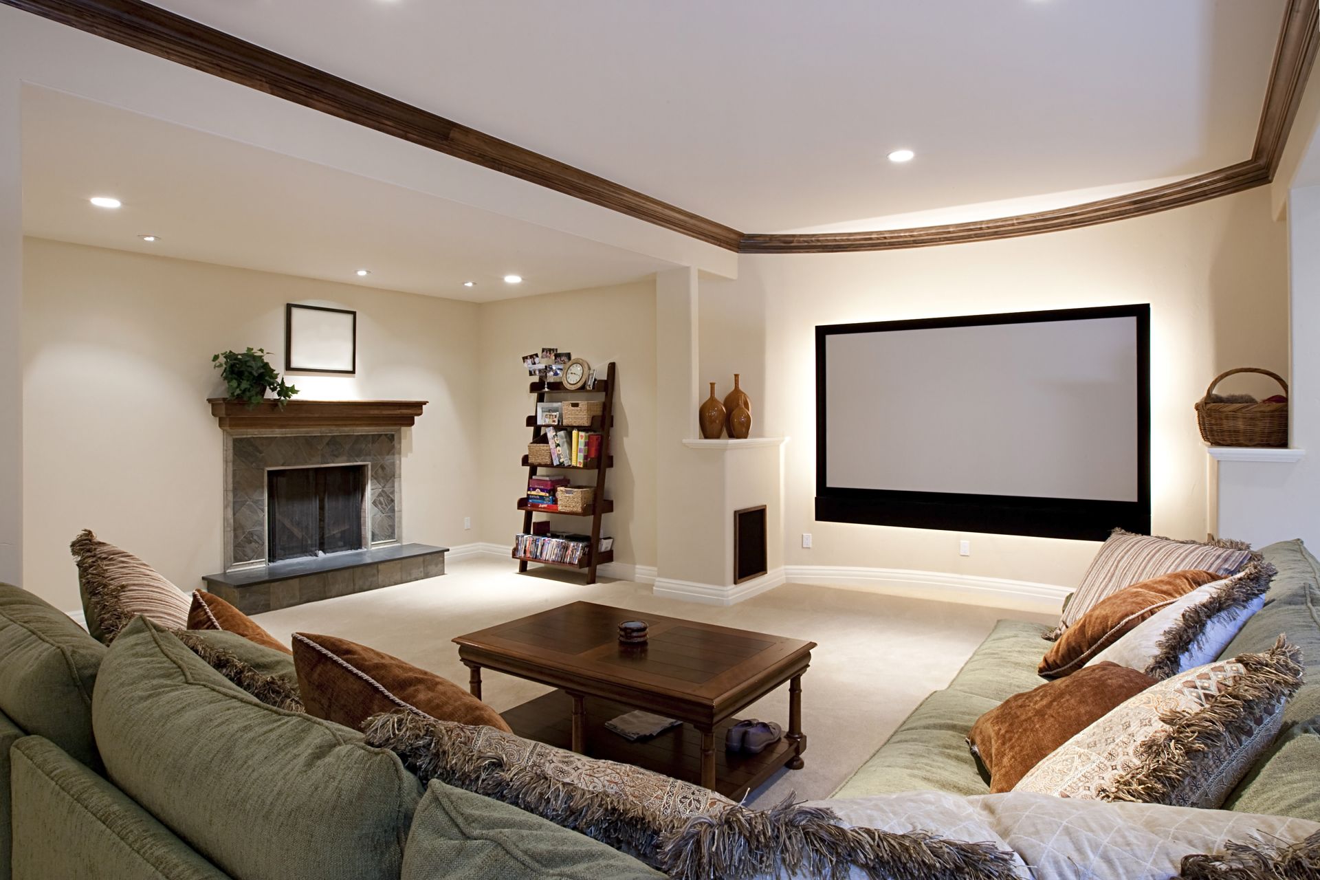 Cozy home theater with large screen, fireplace, and green sectional sofa.