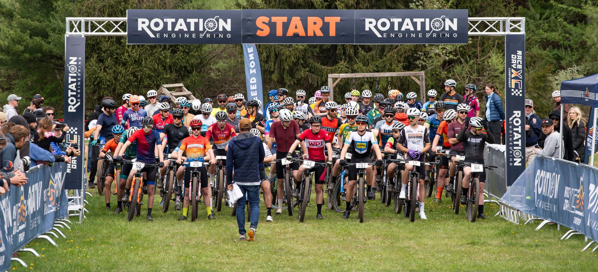 Cyclists on mountain bikes at the starting line of a race under a
