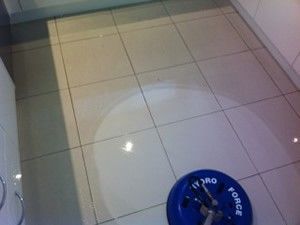a blue weight plate is sitting on a tiled floor in a kitchen .