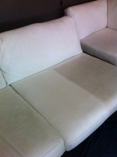 a white couch is sitting on top of a blue carpet in a living room .