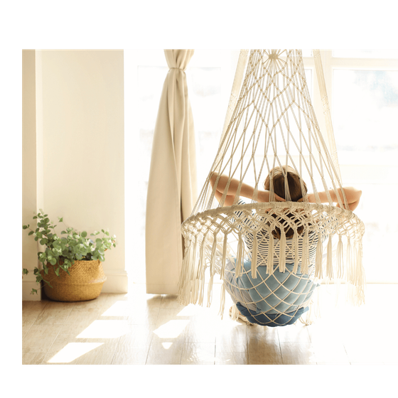 women facing window in a hanging chair.