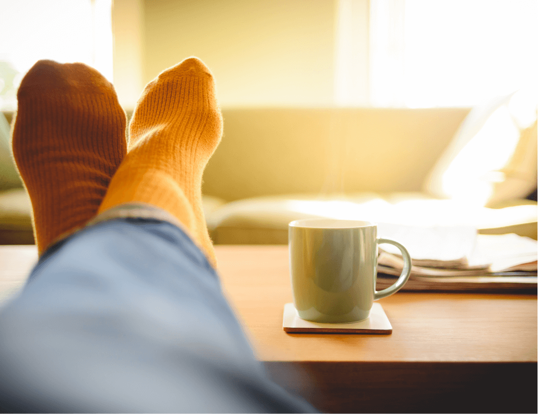 Picture showing feet on coffee table with cup of coffee.