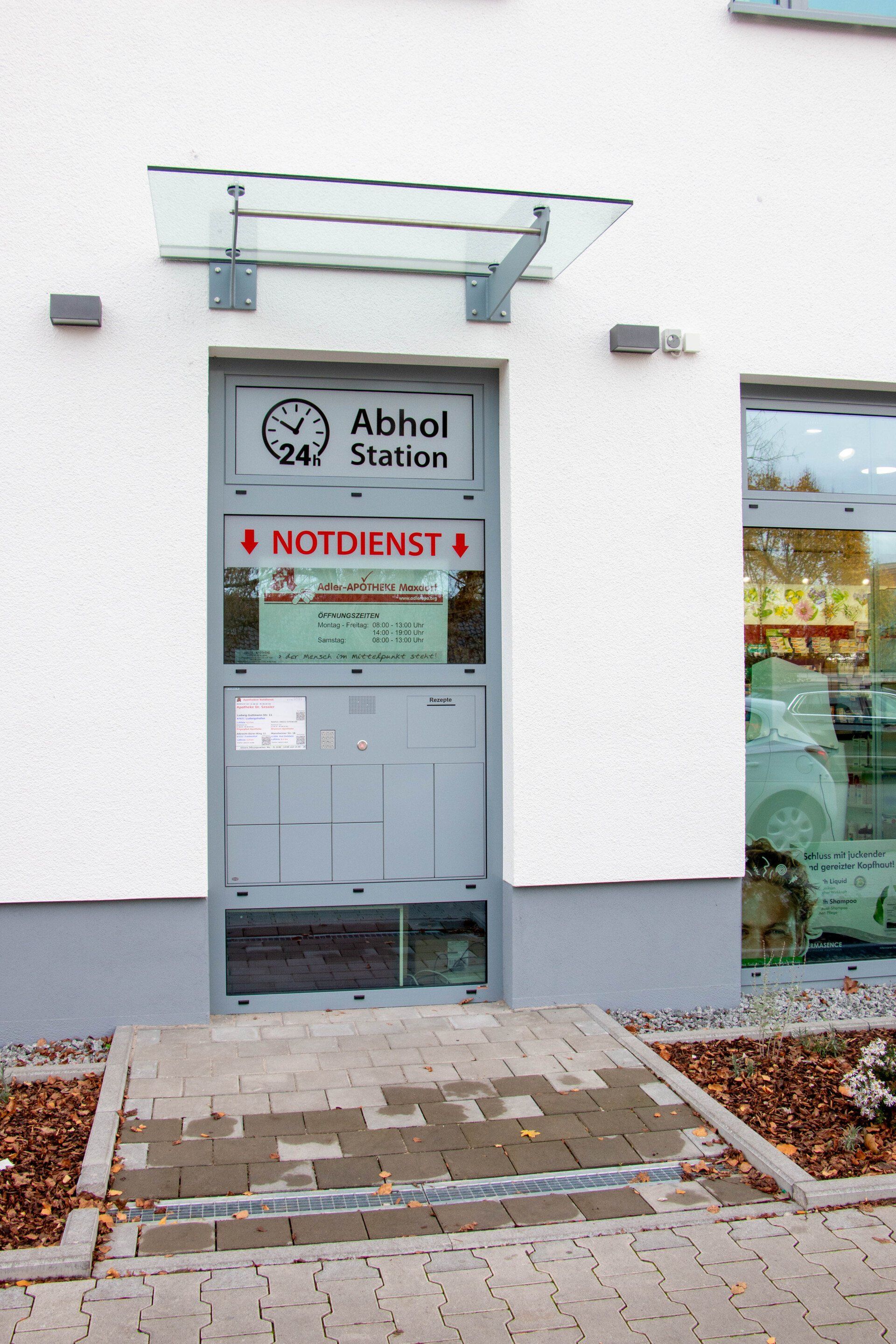 Ein weißes Gebäude mit einer Tür, auf der „Notdienst“ steht