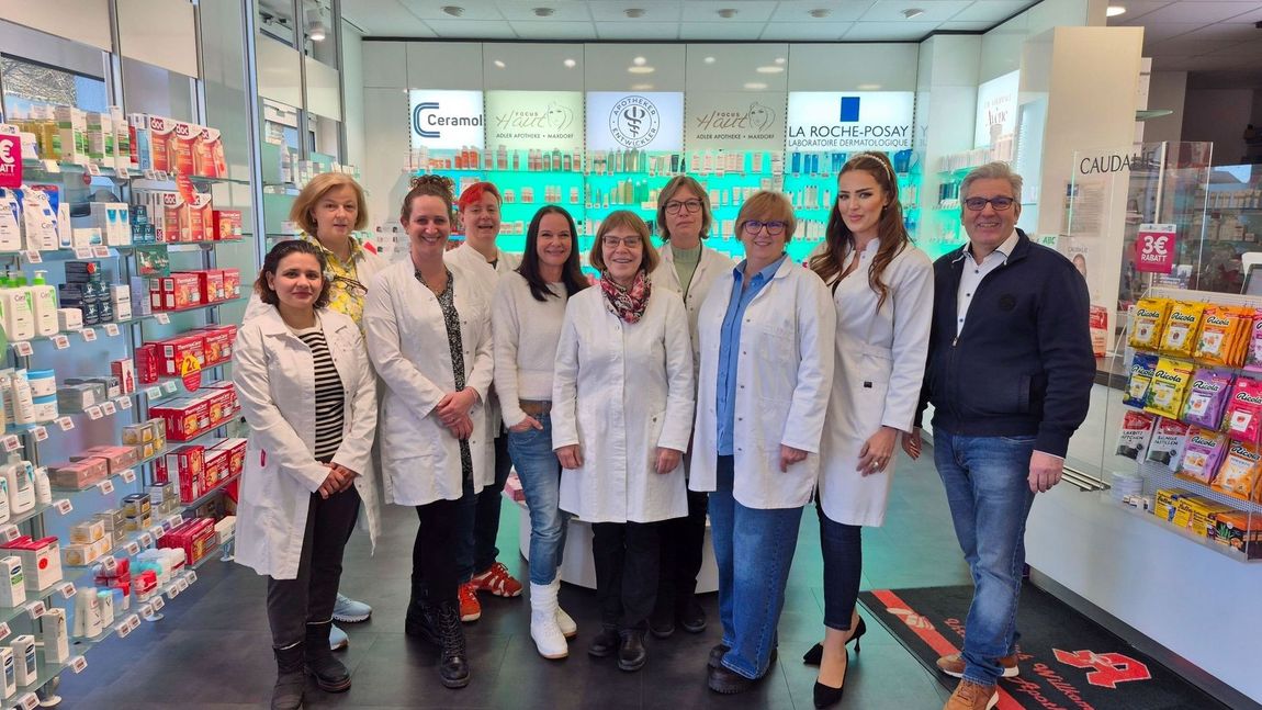 Eine Gruppe von Menschen posiert vor einem Gebäude für ein Foto.