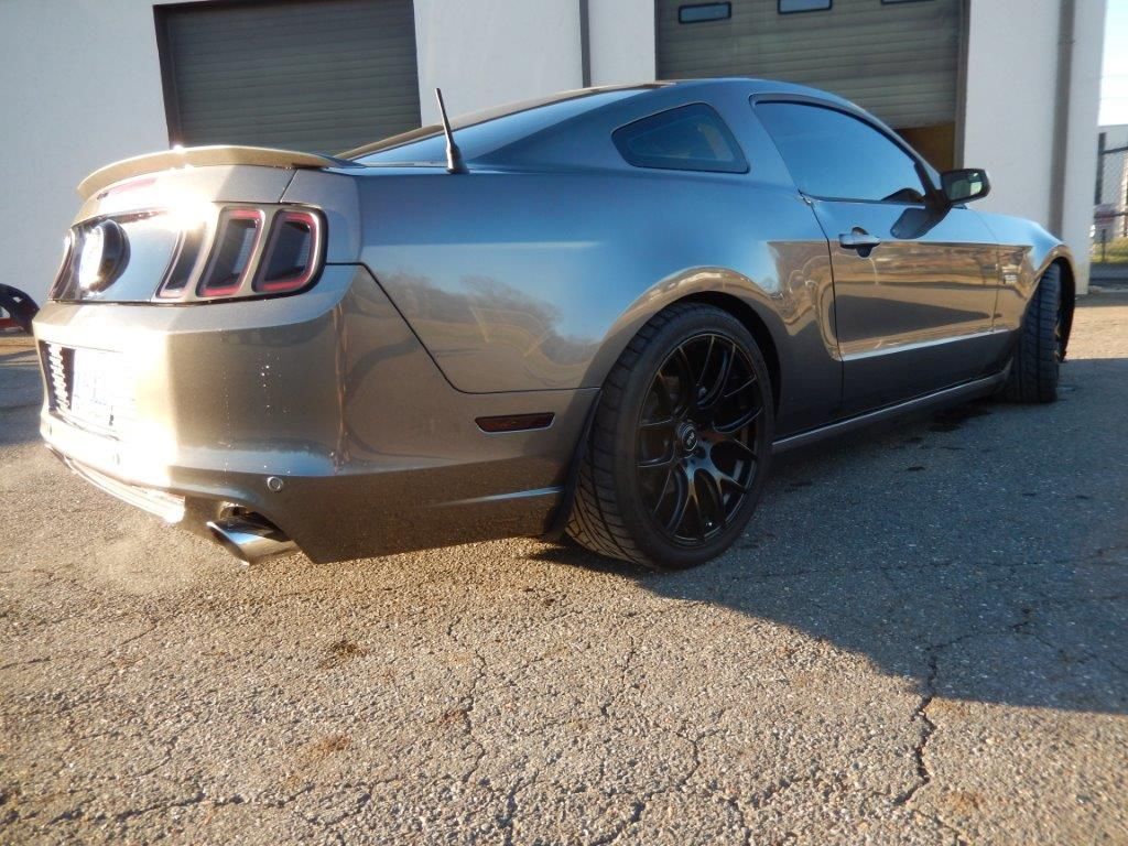 Gray Ford Mustang sports car parked outside.