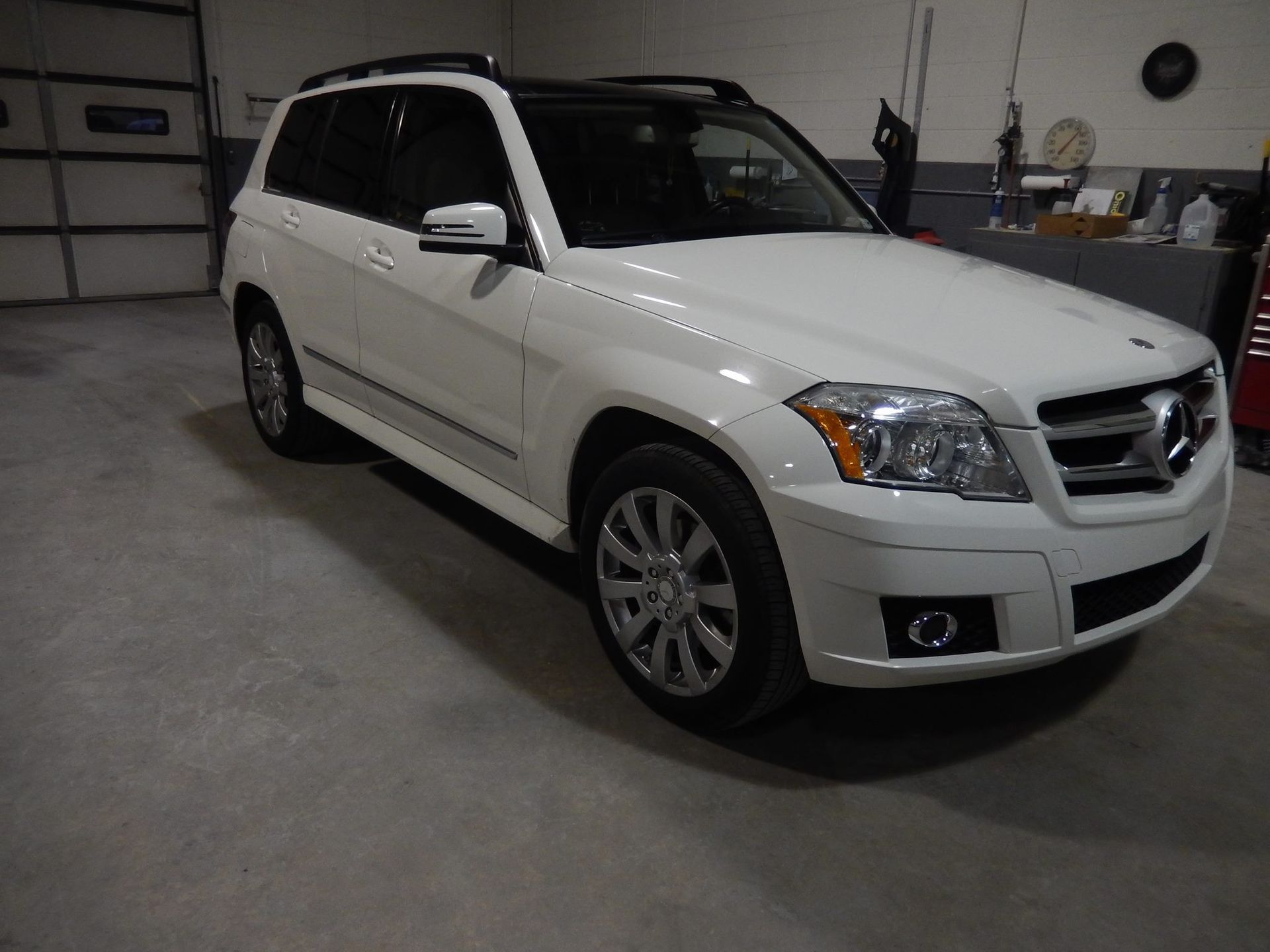White Mercedes-Benz GLK SUV in a garage setting with a concrete floor.