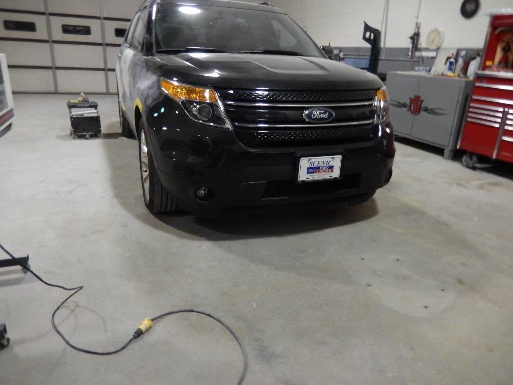 Black Ford Explorer SUV in a repair shop.