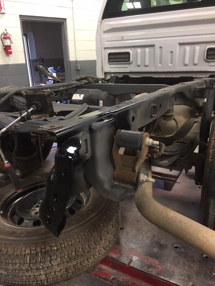 Rear truck frame with suspension components and exhaust pipe.