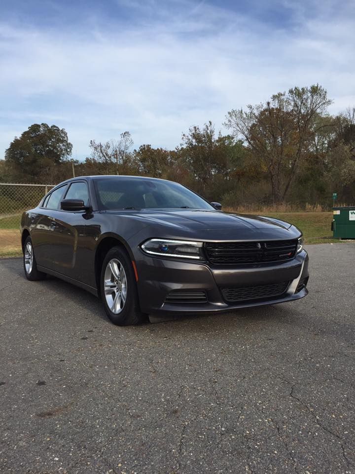 Gray Dodge Charger parked on asphalt, outdoors on a sunny day.