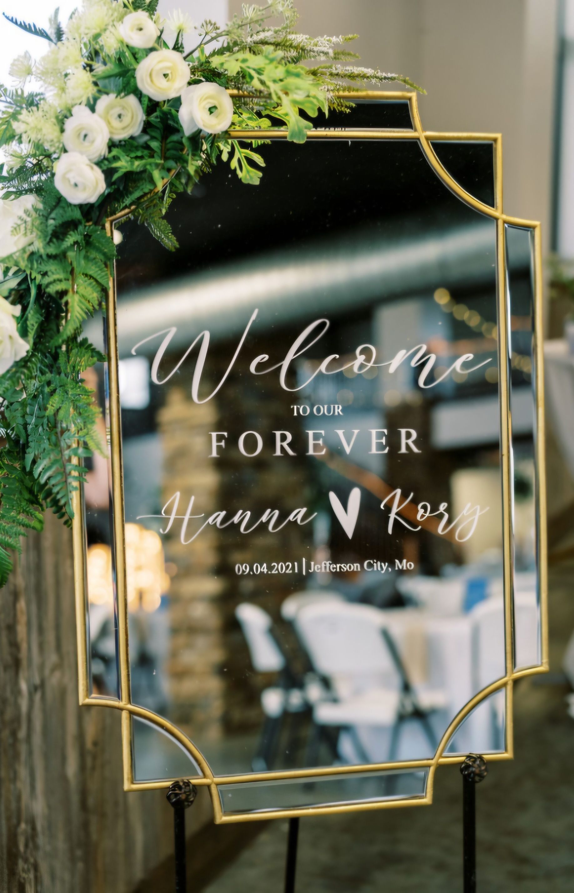 A welcome sign for a wedding is hanging on a wall.