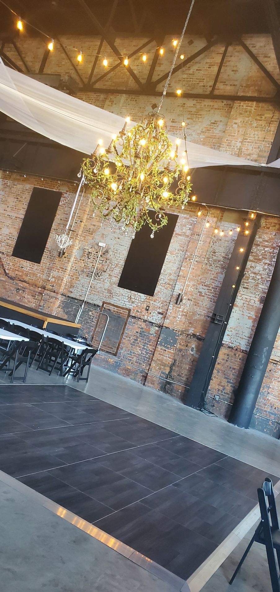 A large room with a wooden floor and a chandelier hanging from the ceiling.