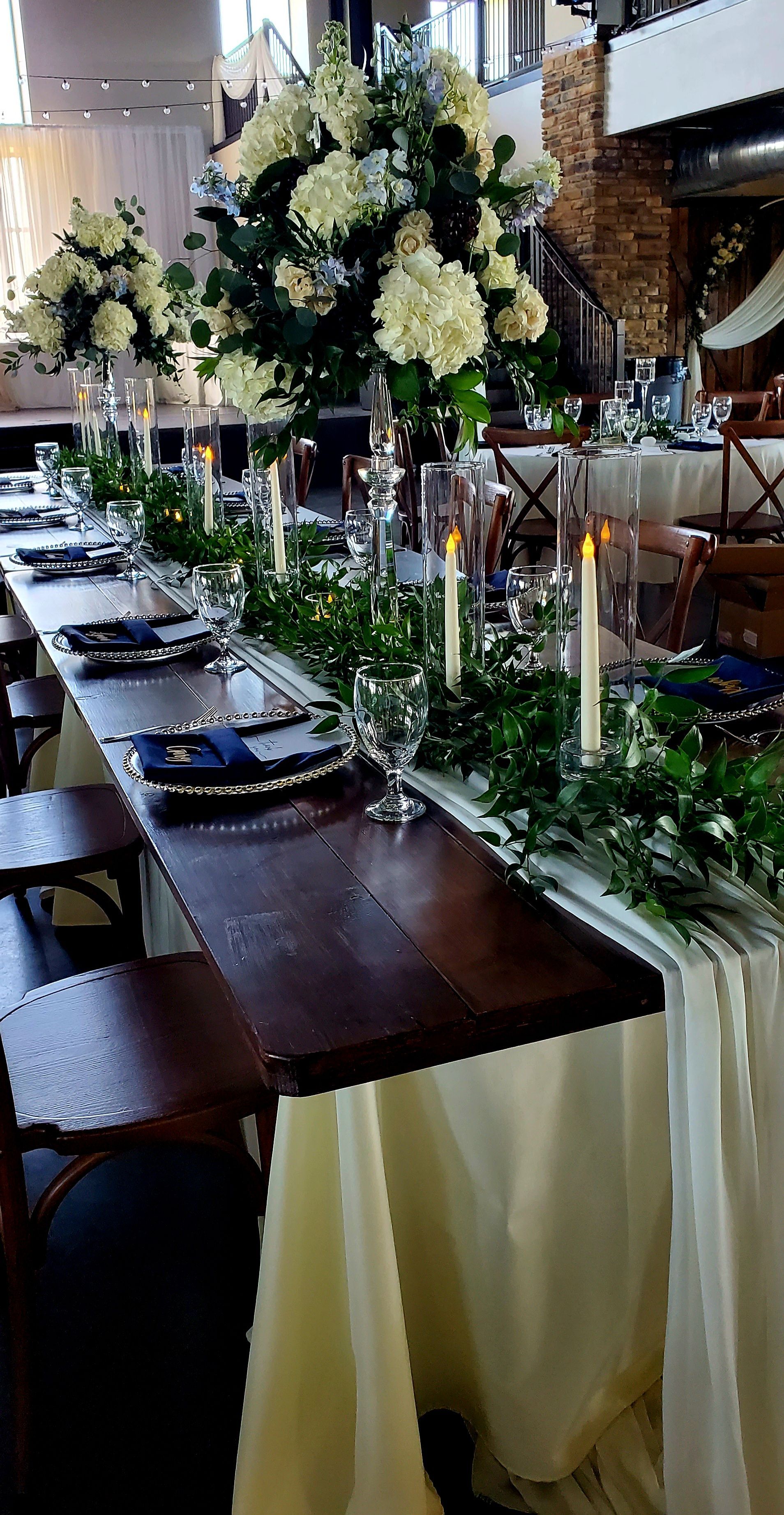 A long wooden table with candles and flowers on it.