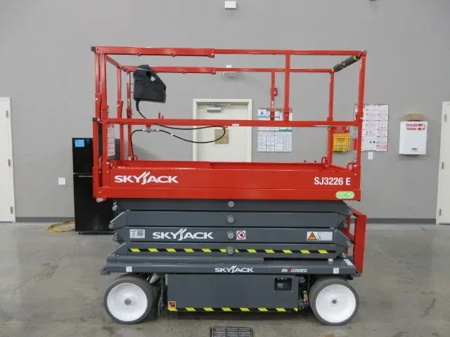 A skyjack scissor lift is sitting in a warehouse