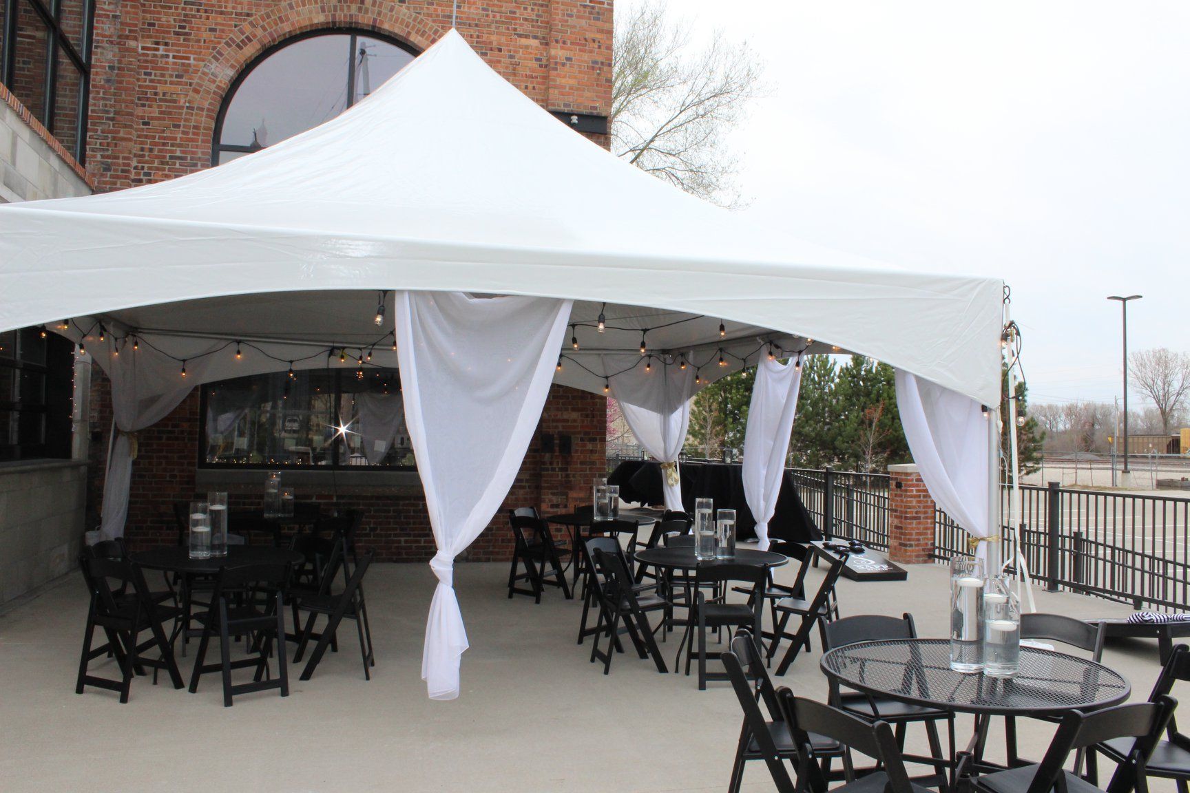 A white tent with tables and chairs underneath it