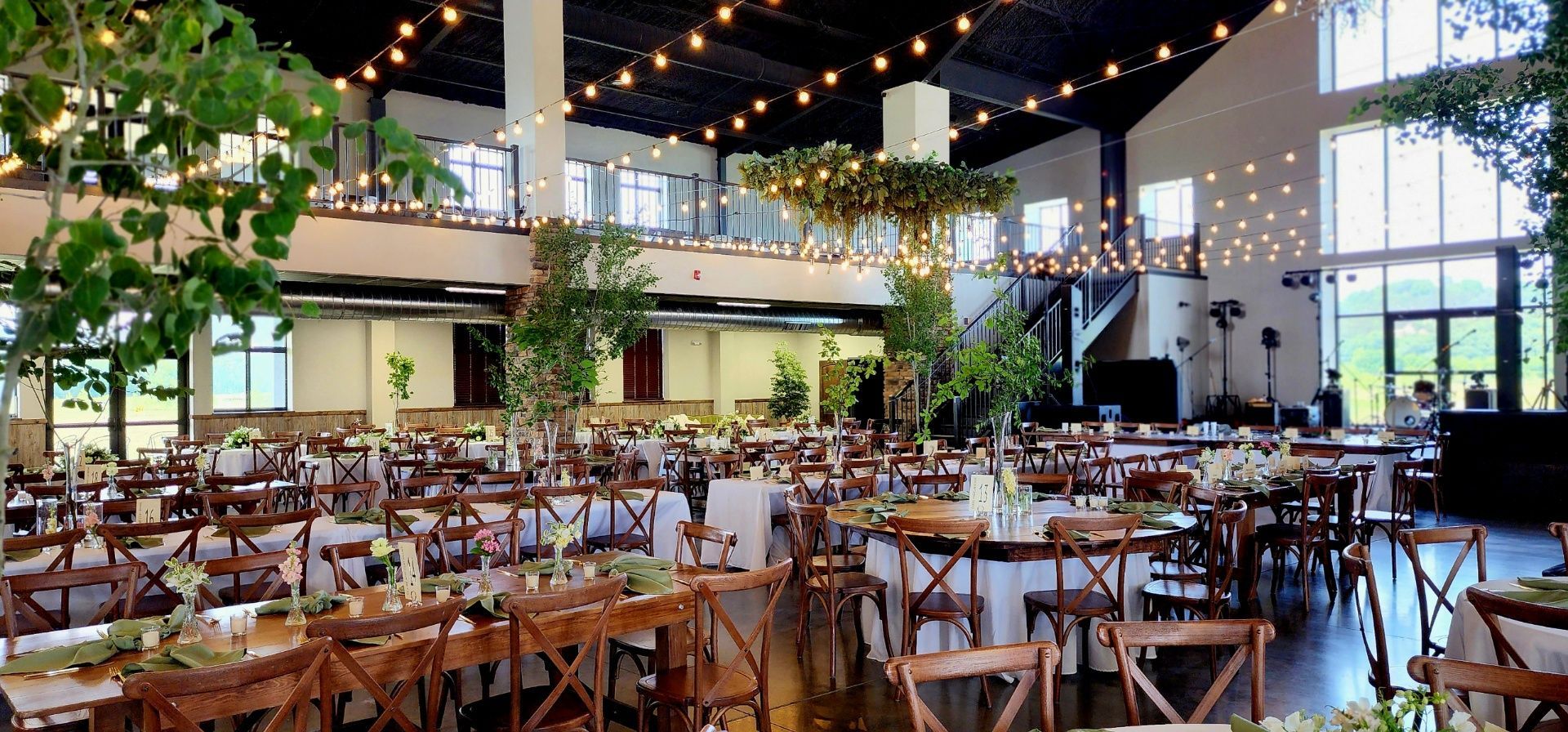 A large room with tables and chairs set up for a wedding reception.