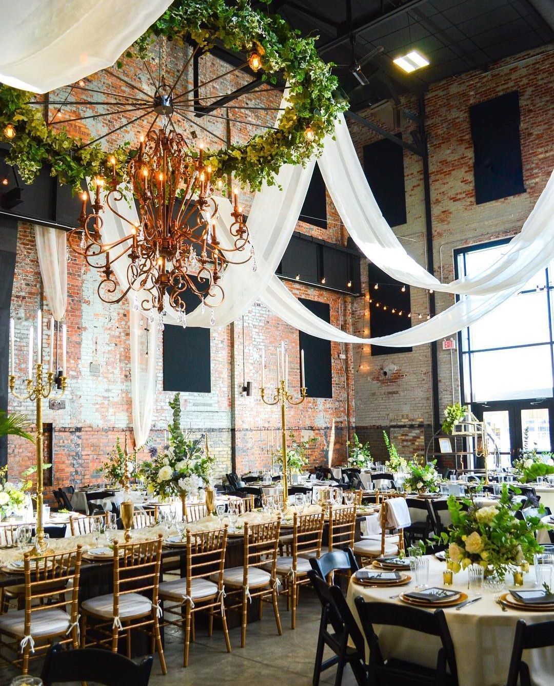 A large room with tables and chairs set up for a wedding reception